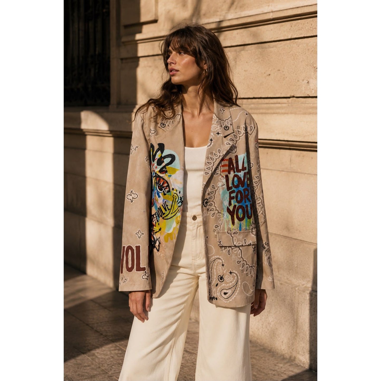 Beige graffiti print statement blazer with paisley design and colourful artwork on the front and back.

