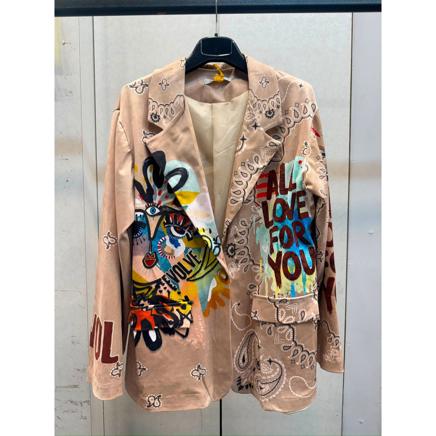 Beige graffiti print statement blazer with paisley design and colourful artwork on the front and back.
